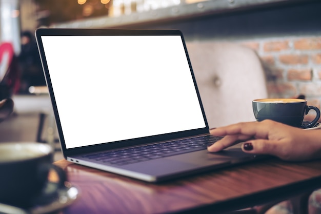 Frau, die Modellcomputerlaptop mit Kaffeetasse verwendet