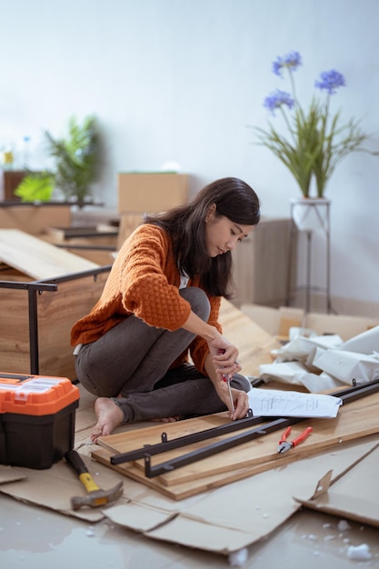 Foto frau, die möbel zu hause repariert