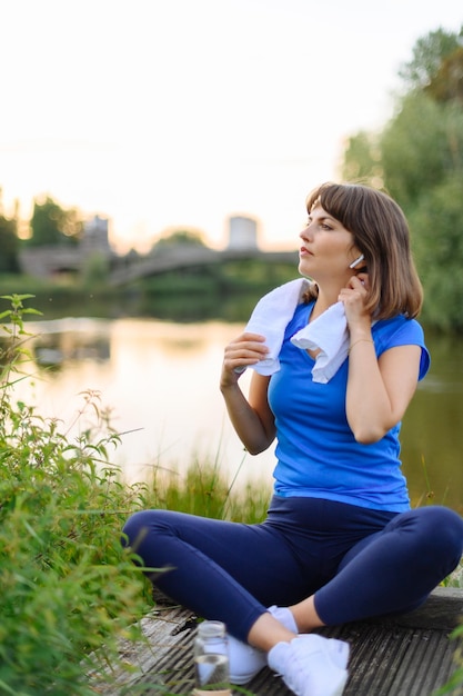 Frau, die müde nach der Fitnesszeit im Stadtpark sitzt