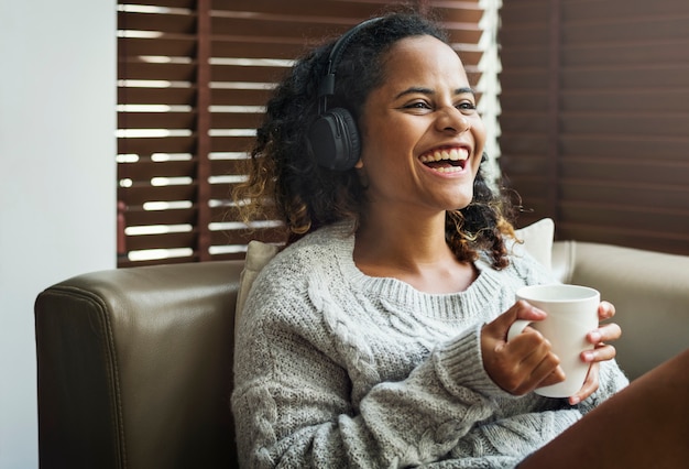 Frau, die Musik auf ihrem Sofa genießt