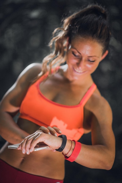 Frau, die nach dem Training im Freien eine intelligente Uhr sieht