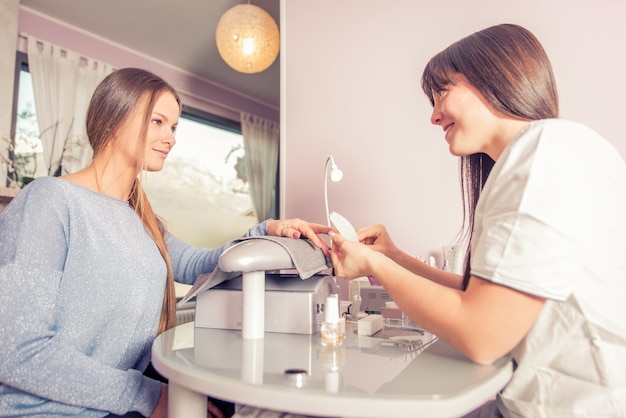 Frau, die Nagelbehandlung in einem Schönheitssalon macht