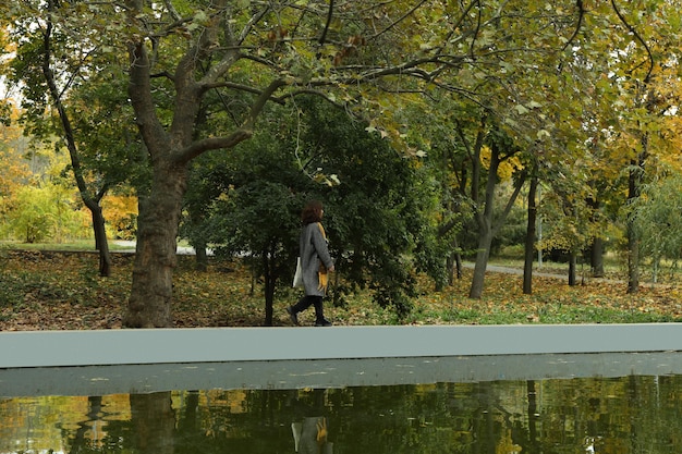 Frau, die nahe dem Teich im Park geht