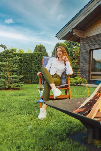 Foto frau, die nahe kamin in ihrem landhaus stillsteht