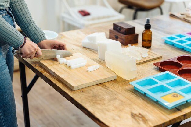 Foto frau, die natürliches glycerin für die herstellung von handwerklicher seife schneidet