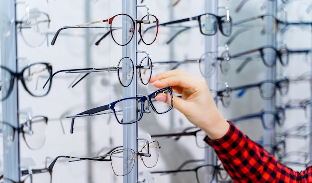 Frau, die neue Brille im Optikergeschäft wählt. Optik. Augenheilkunde.