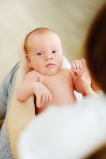 Frau, die neugeborenes Baby zu Hause hält