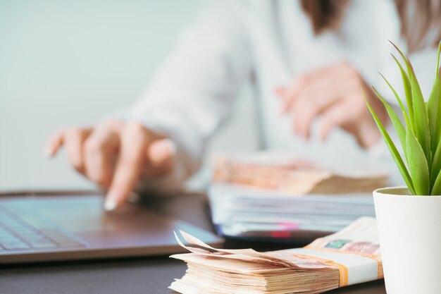 Frau, die oben an der Bürohandlung auf Tastaturabschluß arbeitet. Geld nachzählen