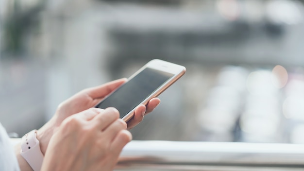 Frau, die öffentlich Smartphone auf Bereichen des Treppenhauses, während der Freizeit verwendet.