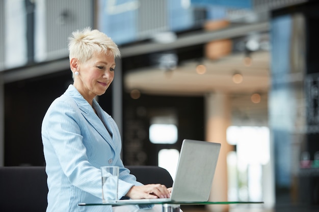 Frau, die online am Laptop arbeitet