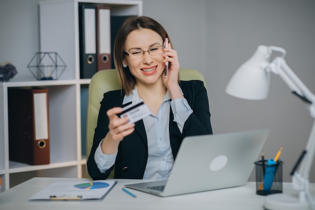 Frau, die Online-Kauf macht. Online-Zahlungsservice. Nahaufnahme von Frauenhänden halten Kreditkarte und Laptop für Online-Shopping.