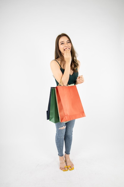 Frau, die Papiertüten mit glücklichem Lächeln auf weißem Hintergrund im Einkaufskonzept hält.