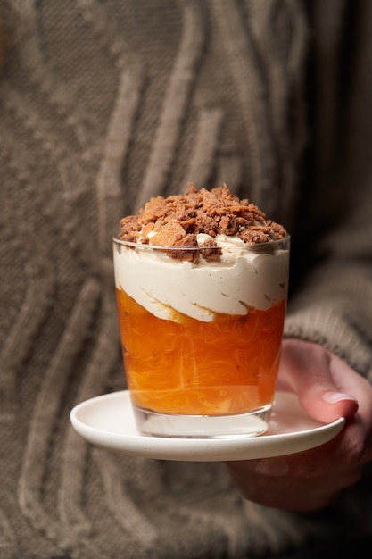 Frau, die Persimmonpudding isst. Frau, die Frühstück mit Persimmon Smoothie mit Joghurtcreme und Schokolade hat