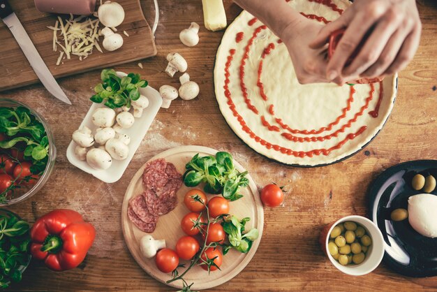 Frau, die Pizza zubereitet