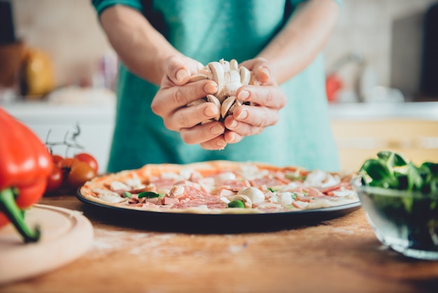 Frau, die Pizza zubereitet