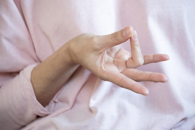 Frau, die Prithvi-Mudra mit ihrer Hand tut