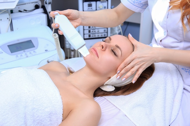 Foto frau, die reinigungstherapie mit einem professionellen ultraschallgerät im kosmetikbüro erhält