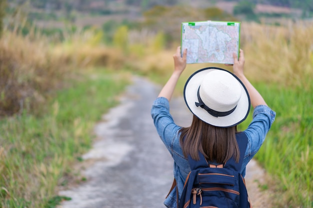 Frau, die Richtung auf Standortkarte beim Reisen sucht