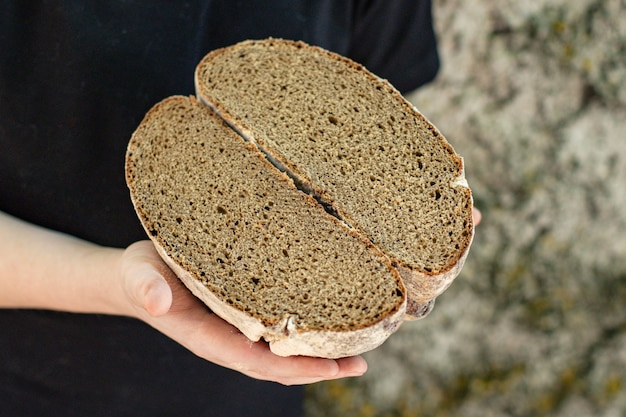 Frau, die Roggenschwarzbrot hält