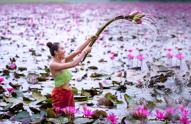 Frau, die rosa Blume im See hält