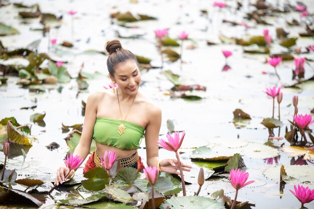 Frau, die rosa Blume im See hält