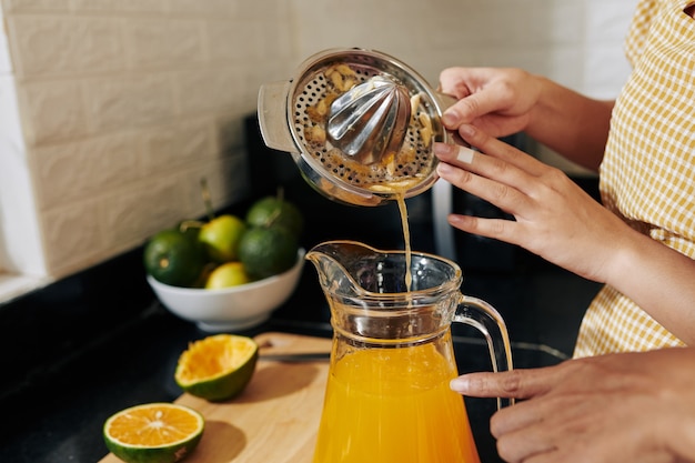 Frau, die Saft in Glas gießt