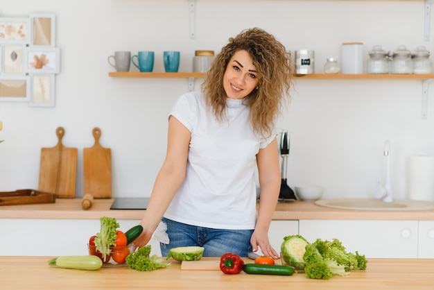 Frau, die Salat in der Küche macht.