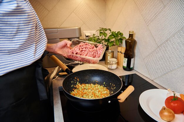 Frau, die Sauce Bolognese in der Küche kocht