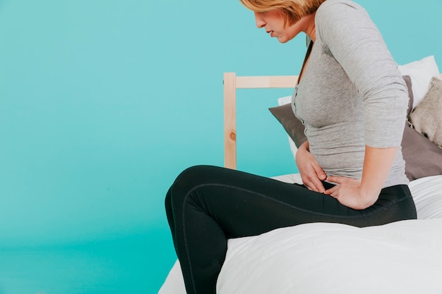 Foto frau, die schmerzenden bauch berührt