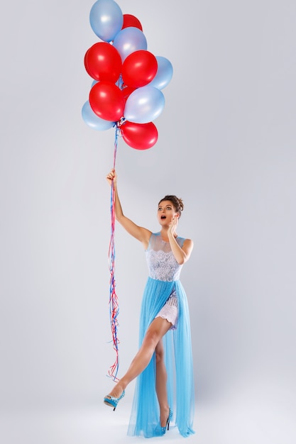 Frau, die schönes Kleid mit vielen bunten Ballonen trägt