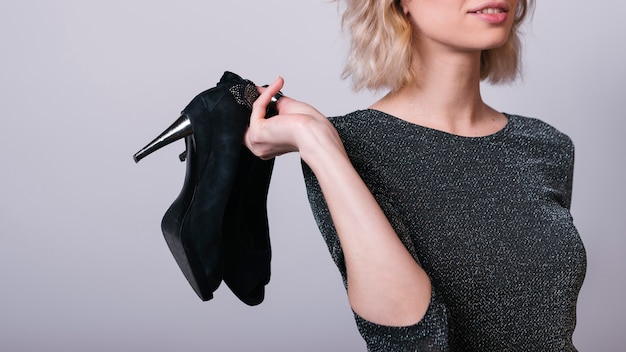 Foto frau, die schuhe in der hand hält