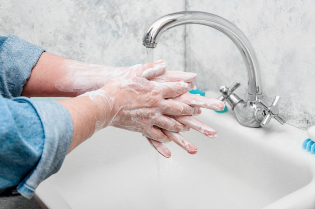 Frau, die sehr sorgfältig Hand mit Seife während des epidemischen Coronavirus wäscht.
