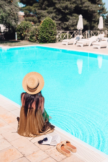 Frau, die sich am Pool in einem Luxushotelresort entspannt und perfekten Strandurlaub genießt