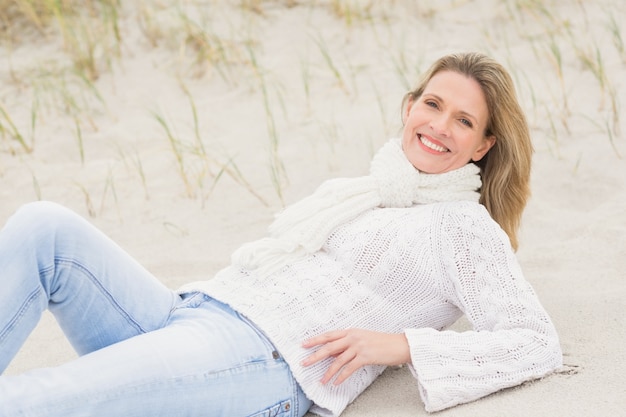 Frau, die sich auf dem Sand hinlegt