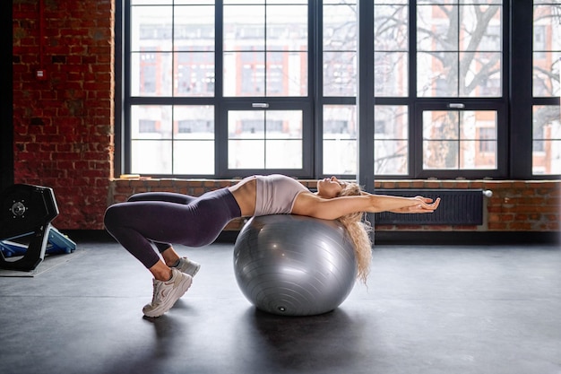 Frau, die sich auf Fitness-Pilates-Ball ausdehnt