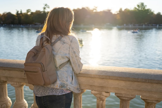 Frau, die sich aus einem großen Süßwassersee im Retiro-Park in Madrid lehnt