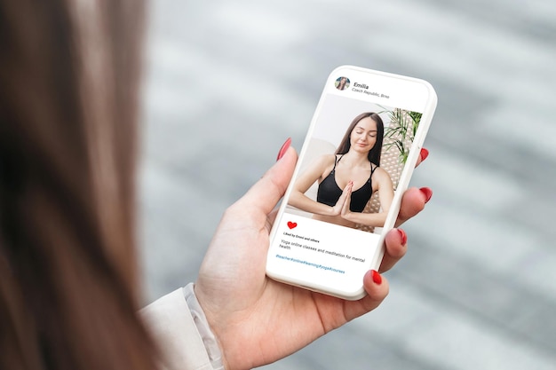 Foto frau, die sich das foto des schönen models beim yoga auf dem handy ansieht