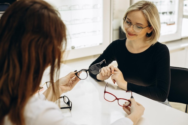 Frau, die sich im Optikgeschäft eine Brille aussucht