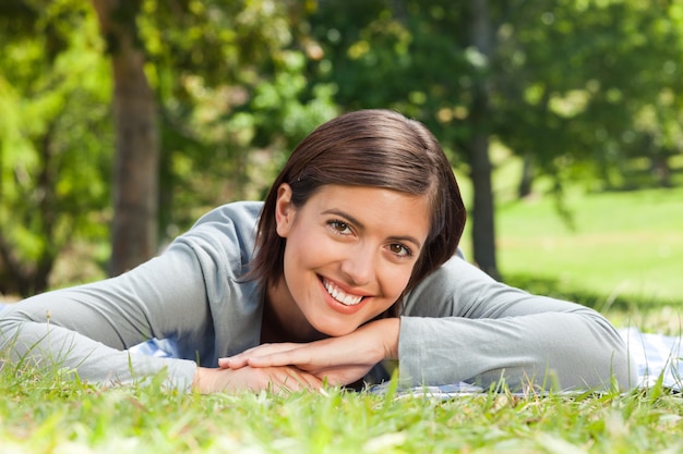 Frau, die sich im Park hinlegt