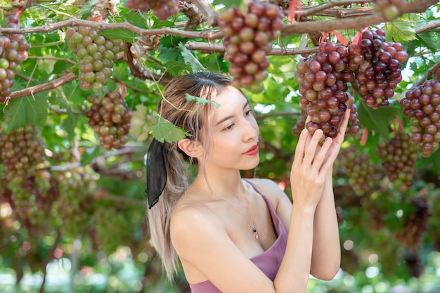 Frau, die sich mit der Natur entspannt, Trauben im Weinberg.