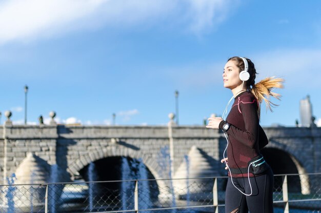 Foto frau, die sich nach dem laufen und joggen in einem park mit sportbekleidung ausstreckt