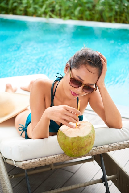 Frau, die sich nahe am Pool sonnen