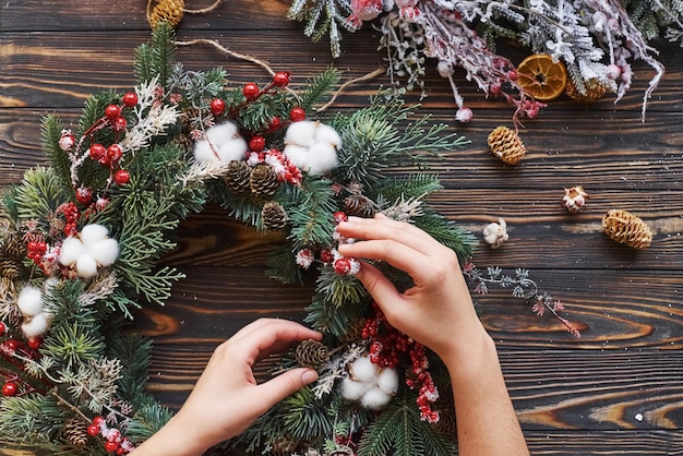 Frau, die sich um Ornament kümmert. Draufsicht des festlichen Weihnachtsrahmens mit Dekorationen des neuen Jahres.