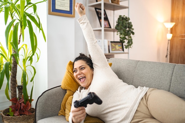 Frau, die sich zu Hause amüsiert und Videospiele spielt