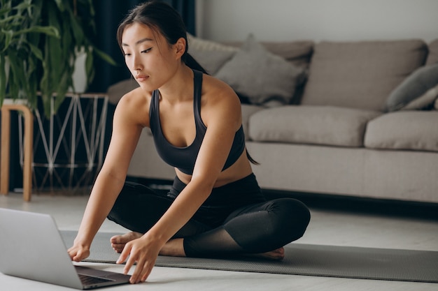 Frau, die sich zu Hause auf Yogamatte ausdehnt