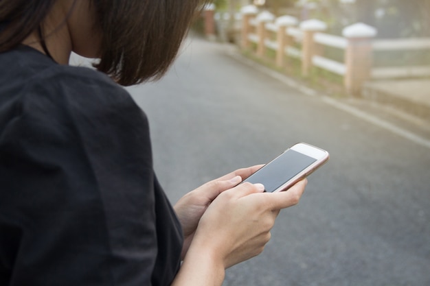 Frau, die Smartphone auf Straße hält