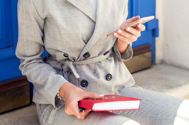 Frau, die Smartphone hält Buch