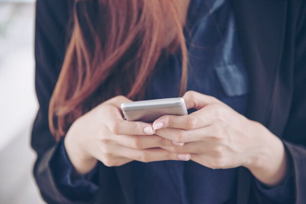 Frau, die Smartphone online einkauft und mit Technologie-Lebensstil anruft. Lächelndes Gesicht der asiatischen Frau, die Handy hält