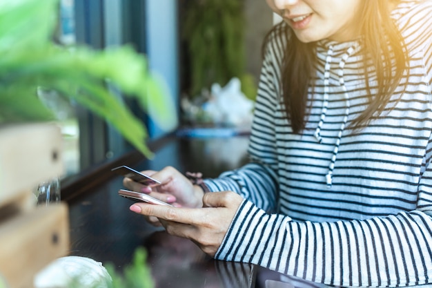 Frau, die Smartphone und Kreditkarte für online kaufen verwendet