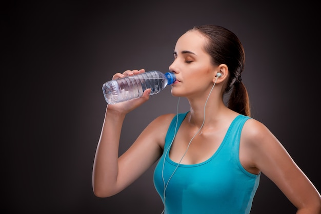 Frau, die Sport mit Flasche Süßwasser tut